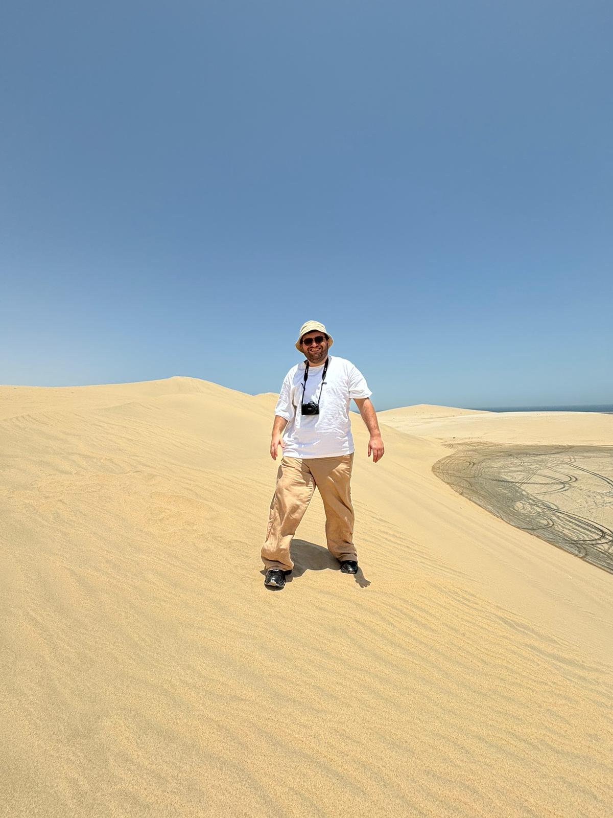 Tyler Port standing on sand dunes